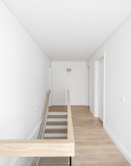 Medinės grindys, ąžuolo masyvo laiptai: spalva 3408 Balta. Medinės durys: dažytos RAL 9003, modelis ED2F.