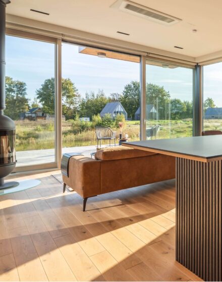 Nature inspired Coastal Interior Featuring Oak Wood Flooring, Earthy Colour Pallete and Captivating Forest Views