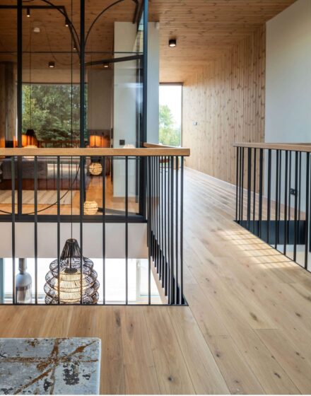 Nature inspired Coastal Interior Featuring Oak Wood Flooring, Earthy Colour Pallete and Captivating Forest Views